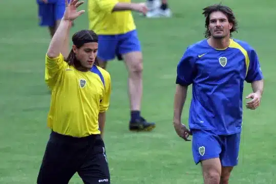 Ezequiel Medrán de buzo amarillo estirando en un entrenamiento.